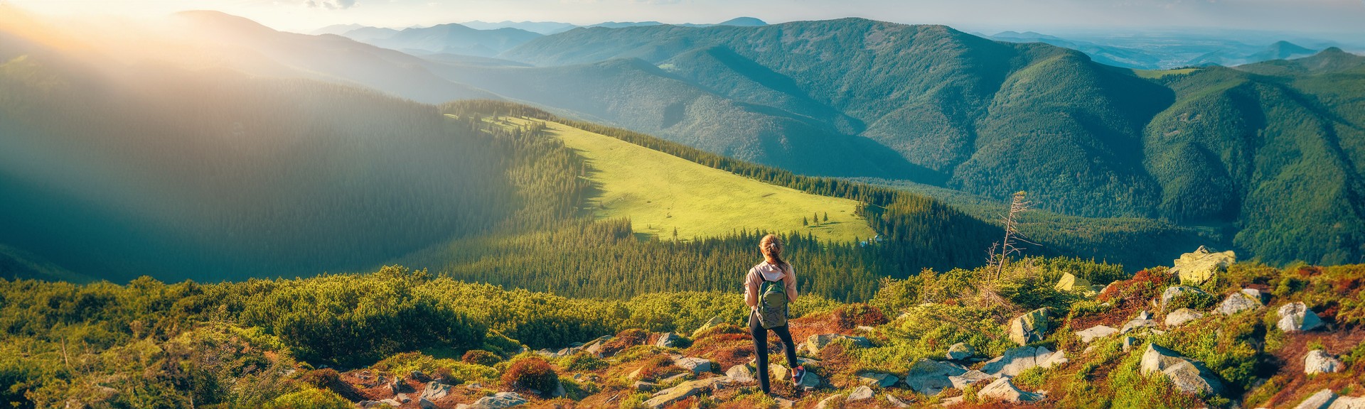 Ukrainian`s Carpathian Mountains and a Standing Woman With a Backpack on the Stones